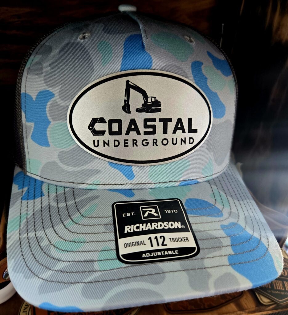 Blue and white Coastal Underground cap with a sticker on the brim.