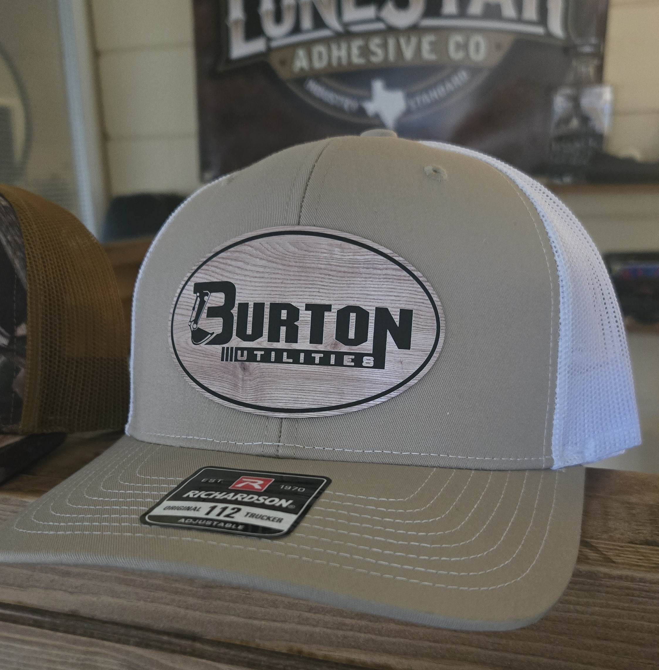 A beige and white Burton snowboard cap on a wooden surface.