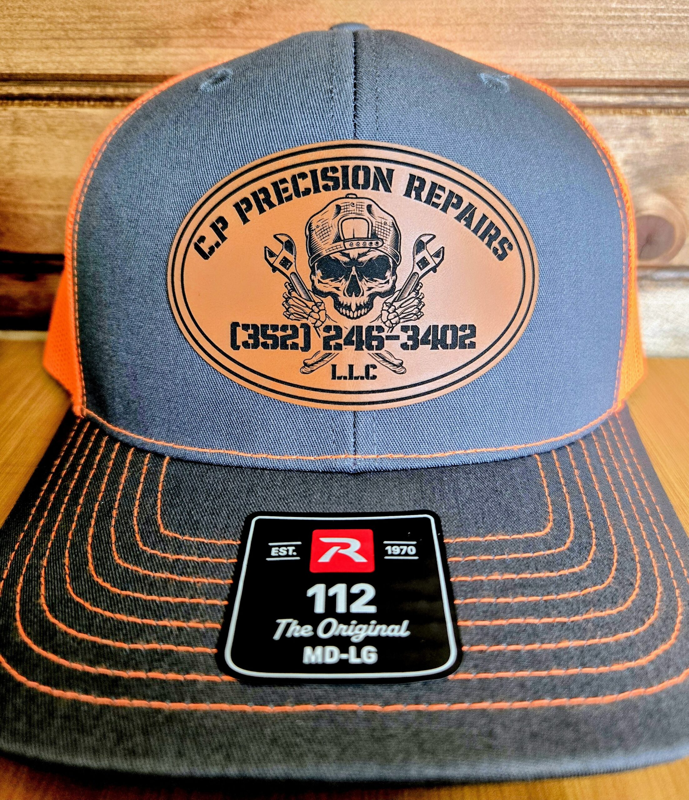 Branded trucker hat with company logo and contact info.