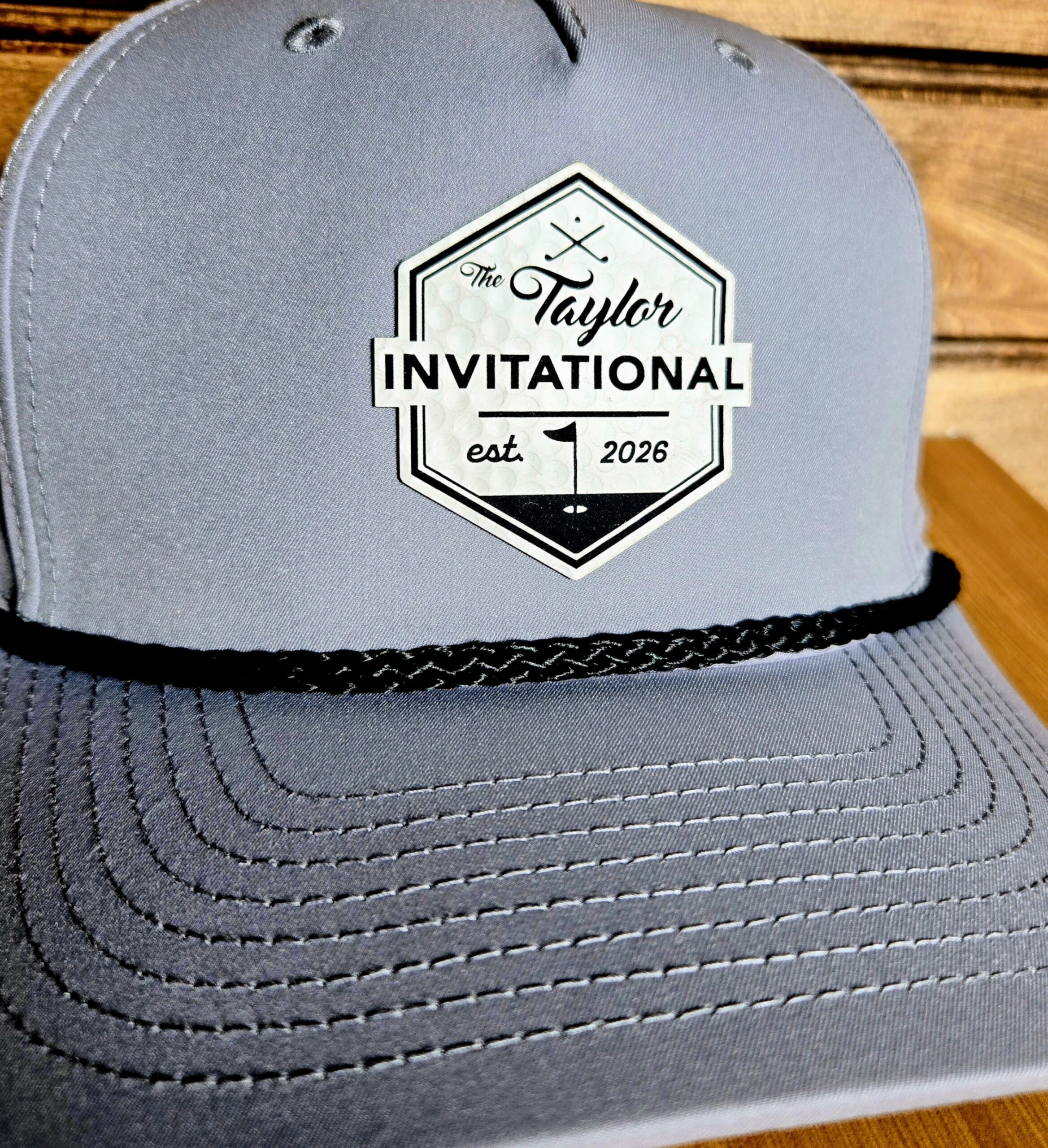 Gray cap with Taylor Invitational logo and black rope detail.
